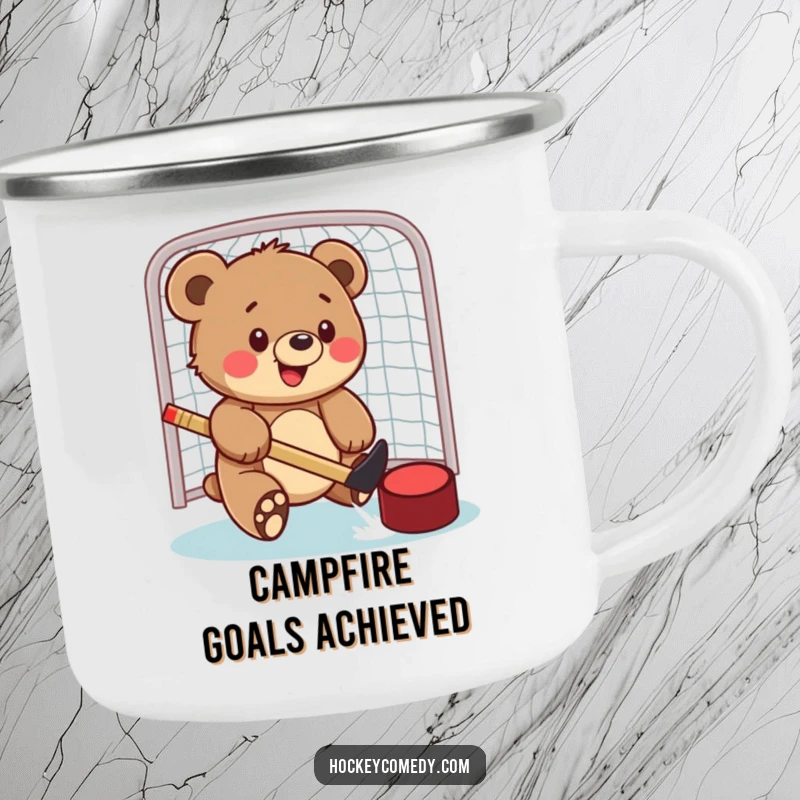 Funny camping mug with a bear cub playfully batting a hockey puck into a net, ideal for enjoying drinks during outdoor activities.