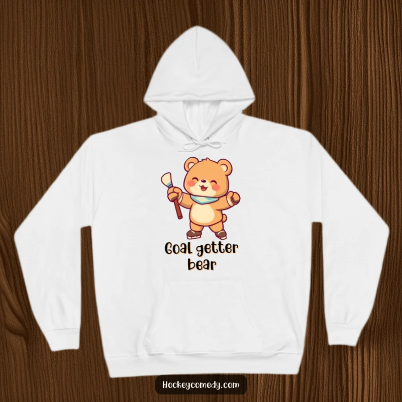 Funny hoodie featuring a joyful bear character striking a hockey pose with a stick, designed for ultimate comfort and sporty style.