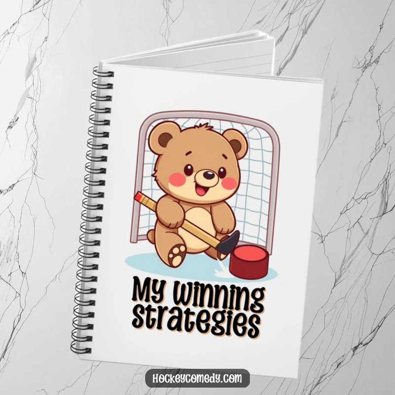 Funny notebook featuring a bear cub swatting a hockey puck into a net, inspiring thoughts about sports and strategy.